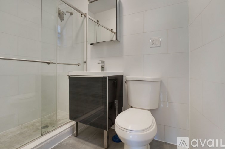 A white toilet sits next to a walk-in shower in a bathroom.