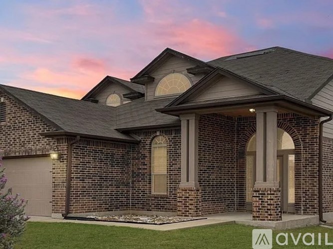 A house with a brick facade and a large arched doorway is available for purchase.