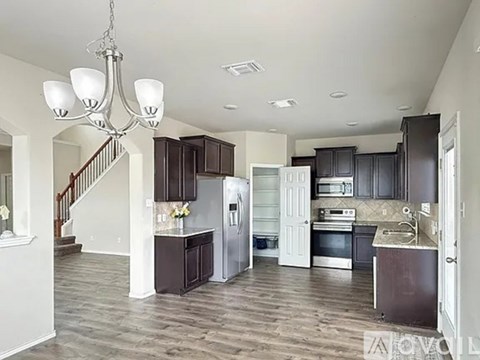 A modern kitchen with dark wood cabinets and a central island.