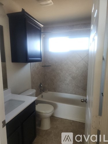 A bathroom with a toilet, sink, and bathtub.