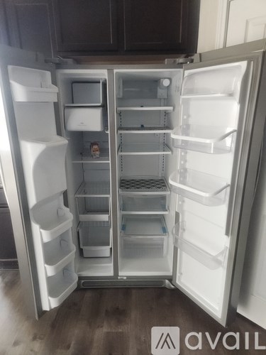 A white refrigerator with its door open and shelves visible.