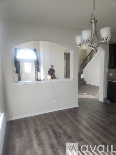 A person is standing on a staircase in a house.