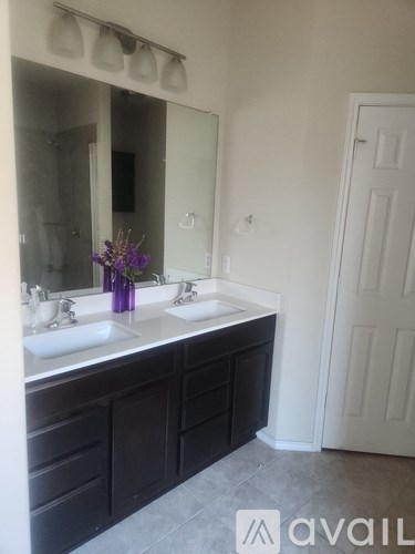 A bathroom with two sinks and a large mirror.