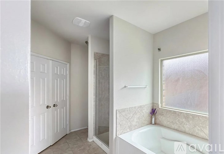 A white bathroom with a tub and shower.
