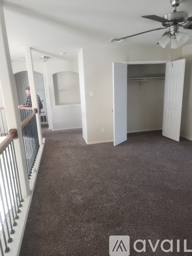 A man is standing on a balcony with a railing.