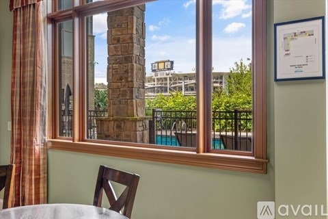 A window with a view of a pool and trees.
