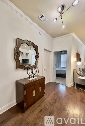 A bedroom with a large mirror and wooden floors.