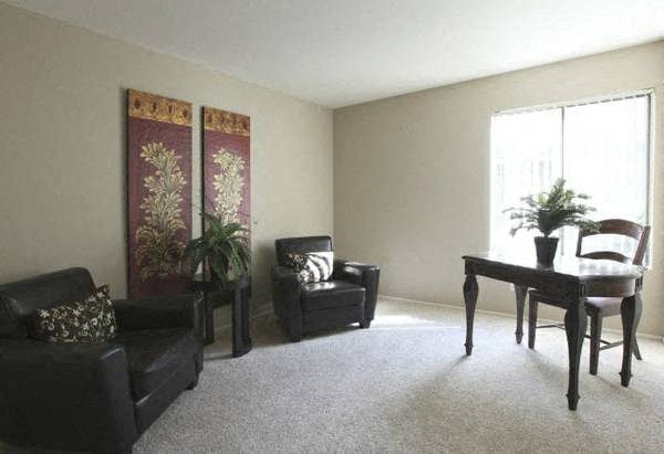 a living room with a piano and chairs