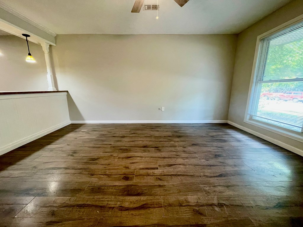 A room with wooden flooring and a window.
