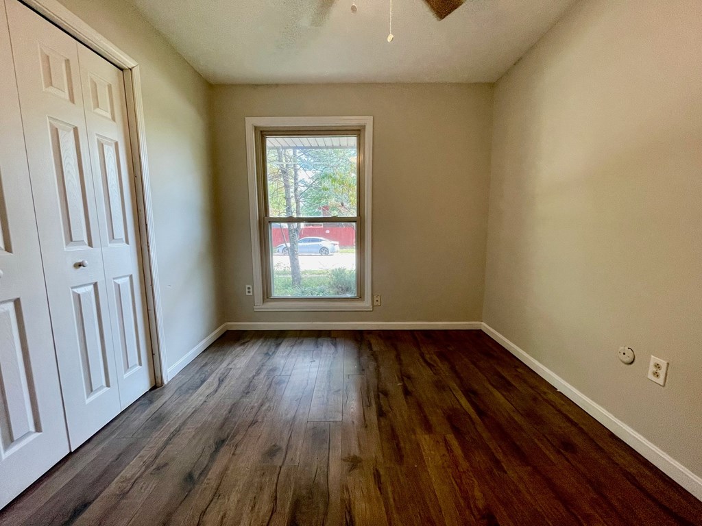 A room with a window and wooden floors.