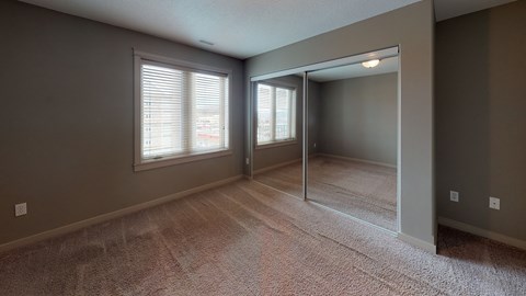 A room with a carpeted floor and a sliding glass door.