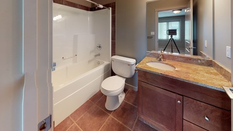 A bathroom with a toilet, sink, and a glass shower stall.