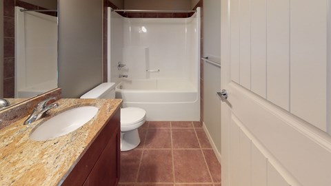 A bathroom with a sink, toilet, and bathtub.
