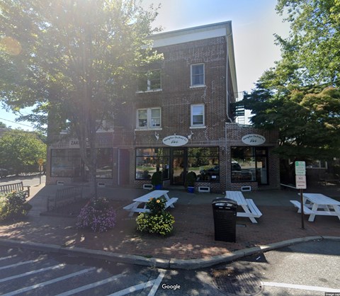 A street view of a building with a sign that says "No Parking" on it.