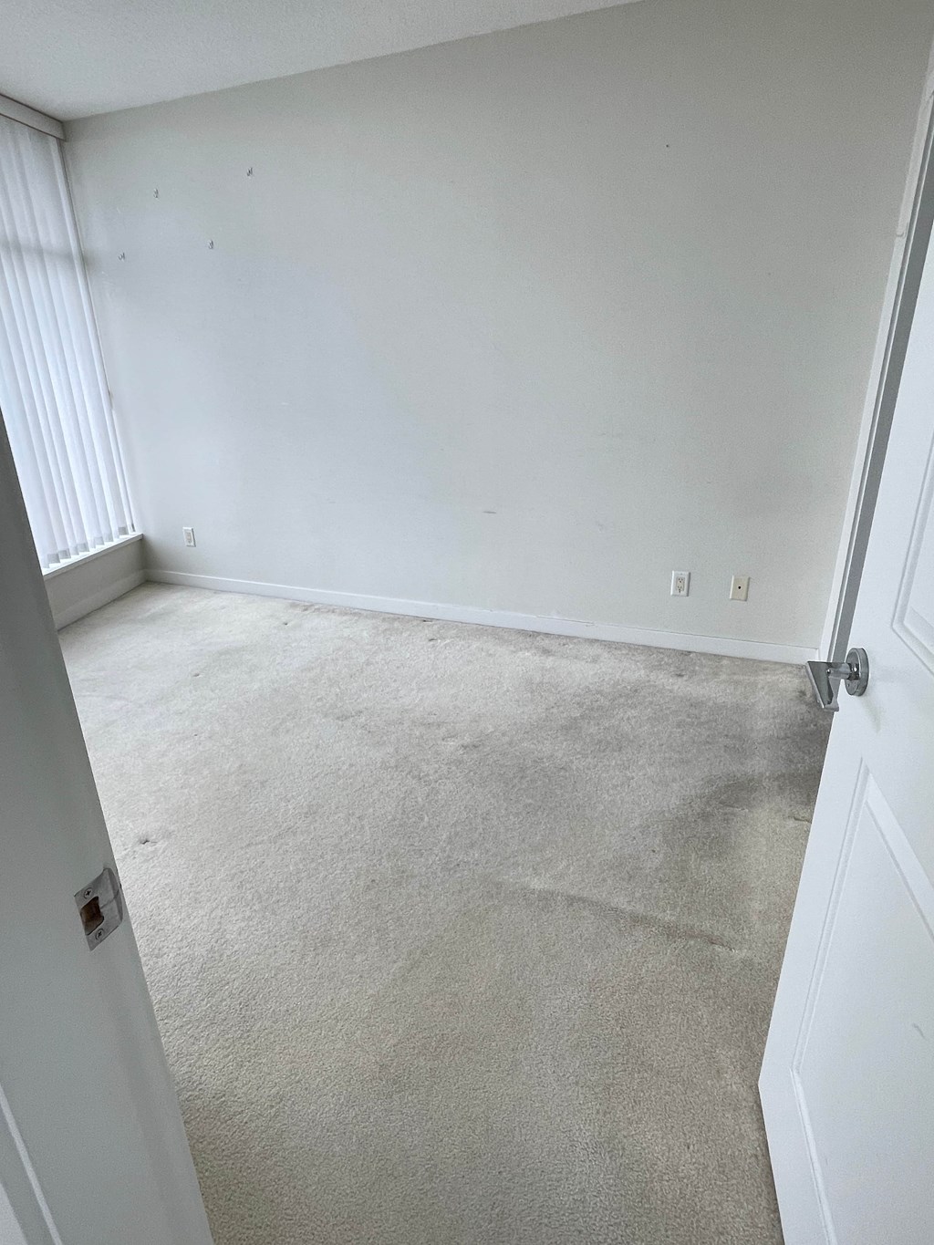 A room with white walls and carpeted floor.