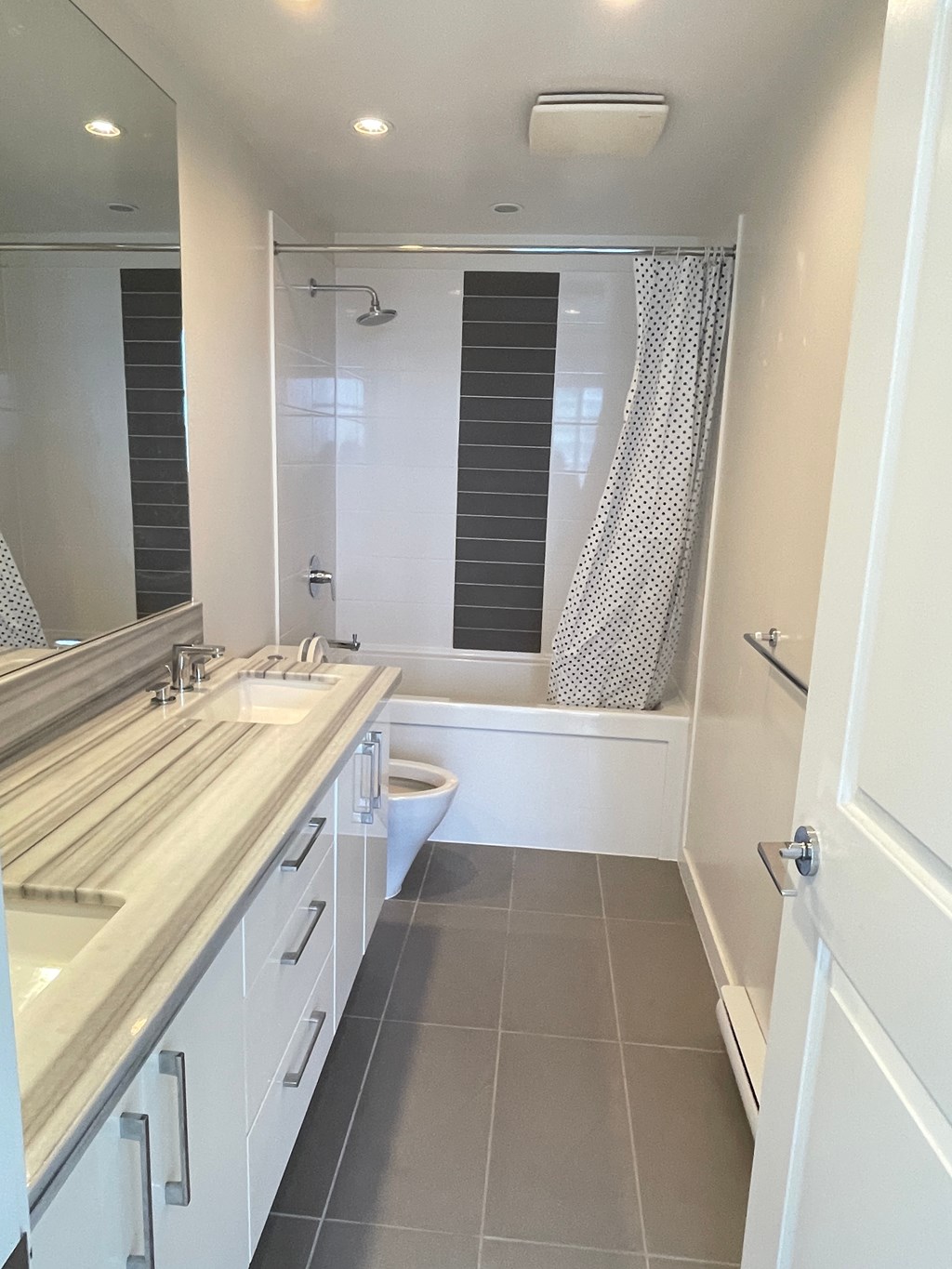 A white bathroom with a shower and sink.