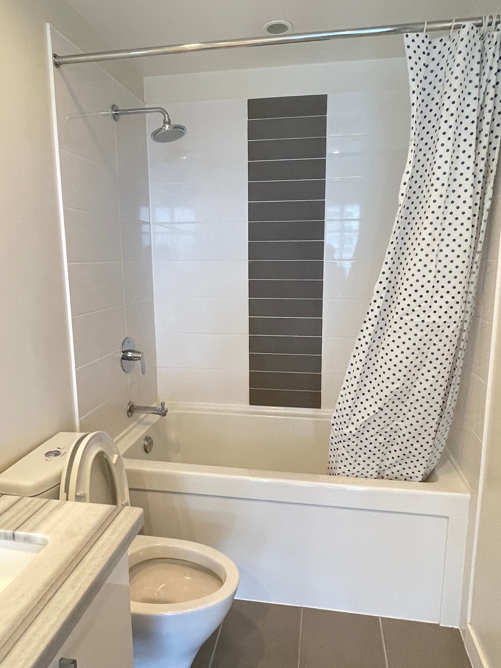 A white bathroom with a toilet, sink, and shower.