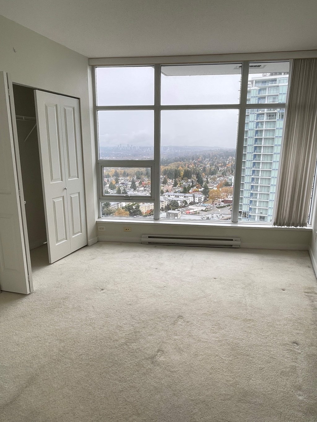 A room with a large window overlooking a cityscape.