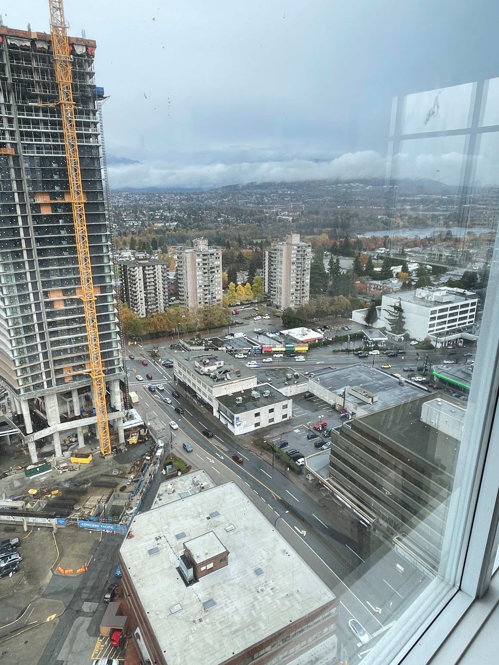A construction site is visible from a high vantage point overlooking a cityscape.
