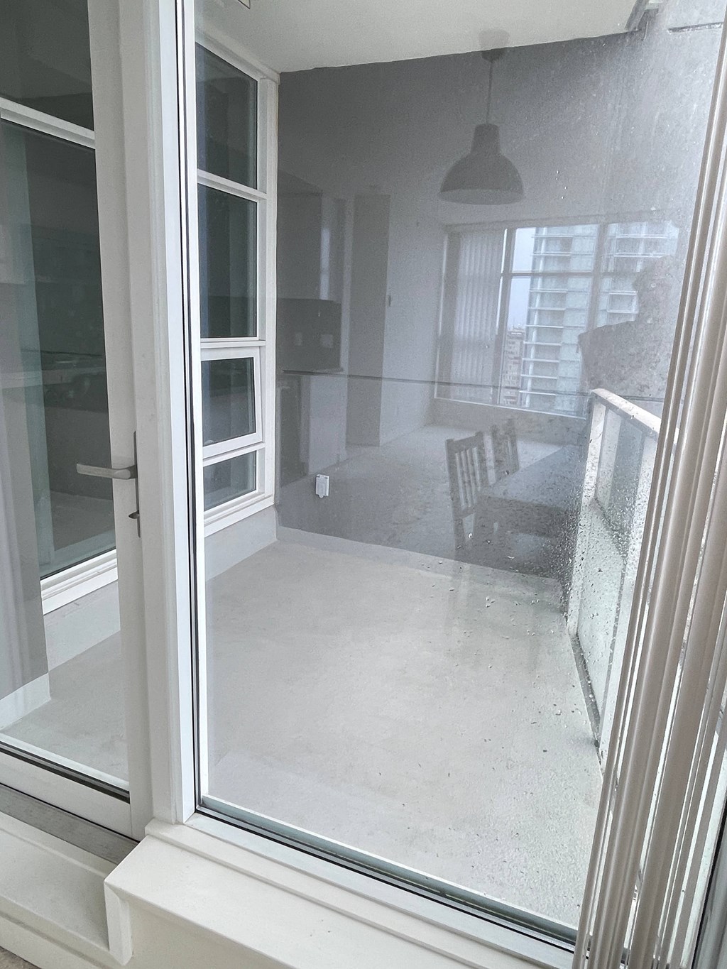 A room with a chair and a table is visible through a wet window.