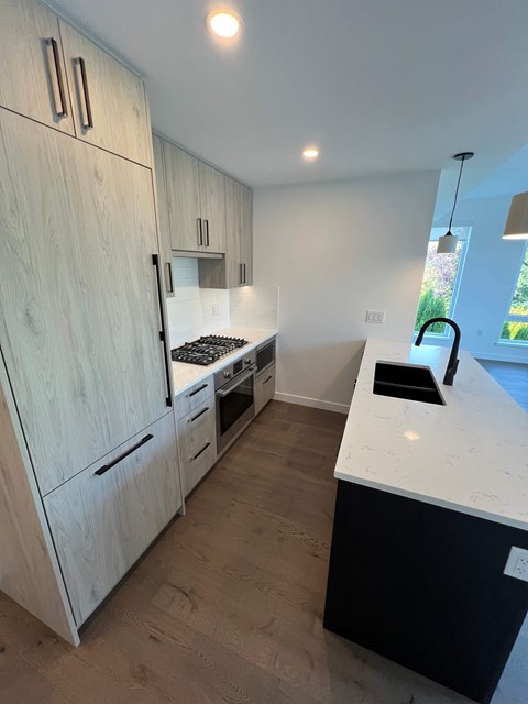 A kitchen with a white counter and wooden cabinets.
