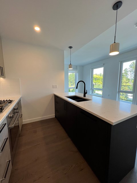 A kitchen with a black counter and a white stove.