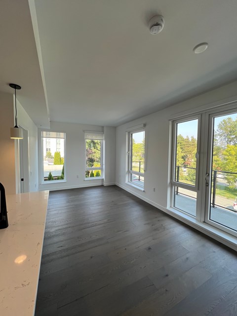 A large, empty room with a white counter and wooden floors.