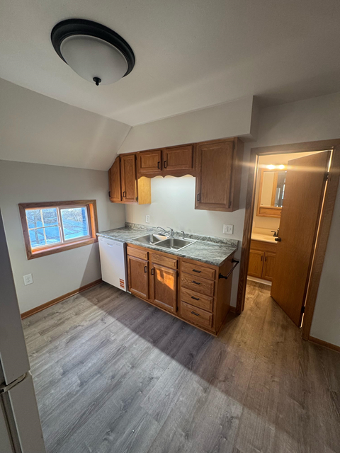 A kitchen with wooden cabinets and a window.