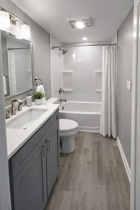 A bathroom with a toilet, sink, and shower.