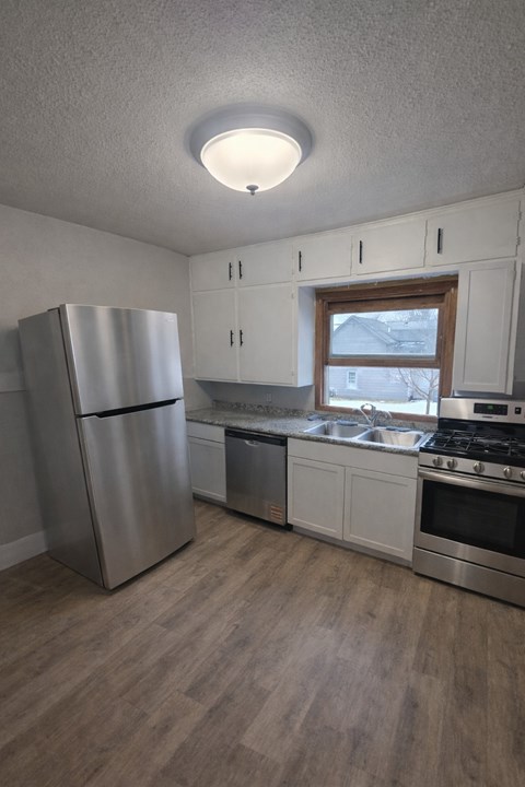 A kitchen with a refrigerator, stove, and oven.
