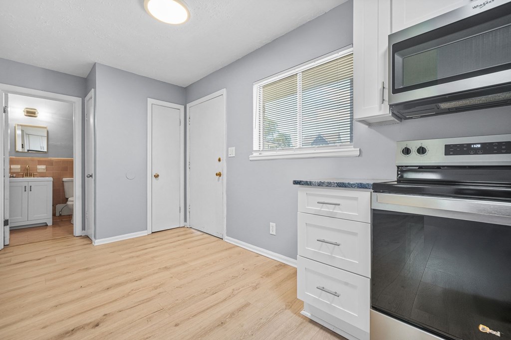 A kitchen with a black oven and white cabinets.