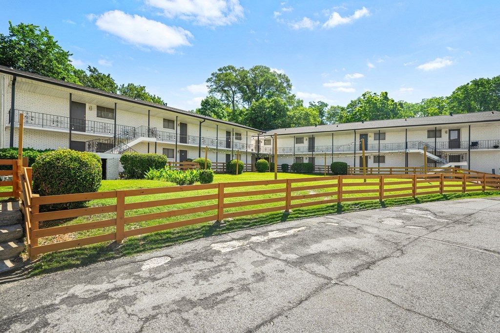 A row of apartment buildings with a wooden fence in front.