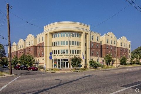 A large building with a sign that says "Maple Woods Apartments West.".