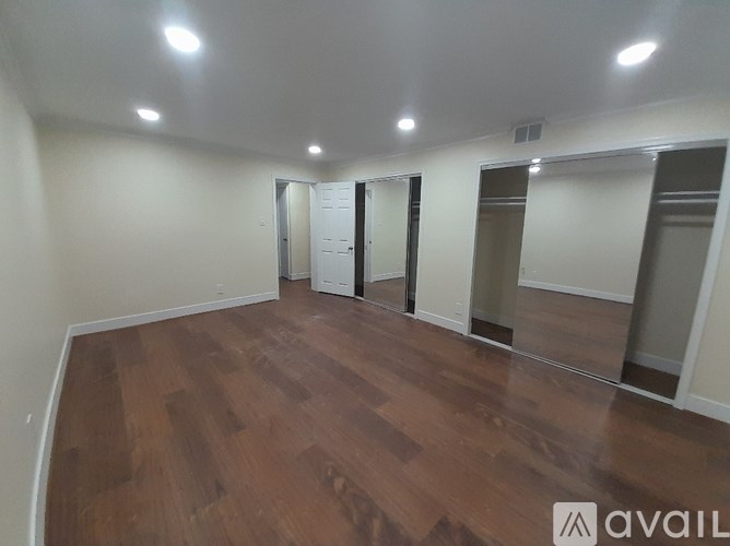 A room with wooden flooring and white walls.