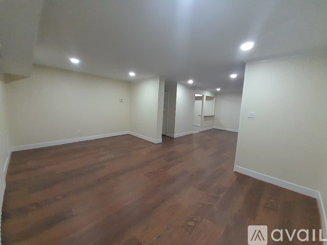 A room with wooden flooring and white walls.
