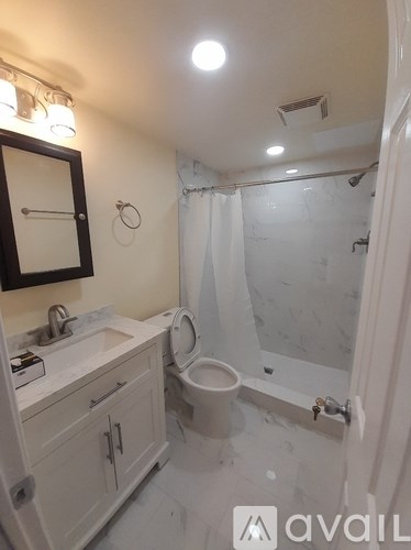 A bathroom with a toilet, sink, and mirror.