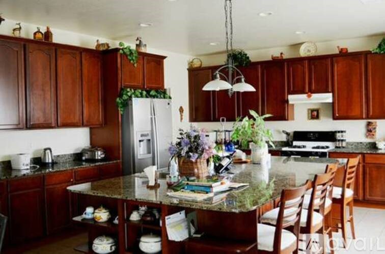 A kitchen with wooden cabinets and a granite countertop.