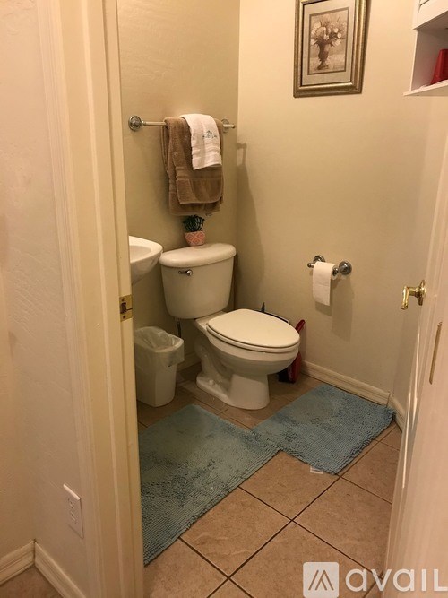 A bathroom with a toilet, sink, and a towel hanging on the wall.