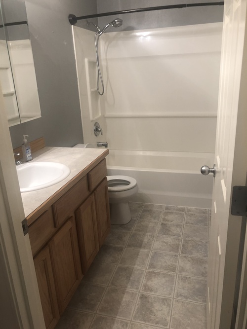A bathroom with a toilet, sink, and shower.