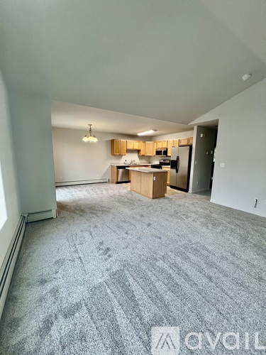 A room with a carpeted floor and a sliding glass door leading to a deck.