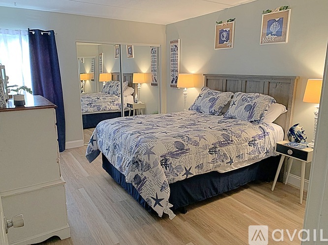 A bedroom with a large bed and two smaller beds in the background.