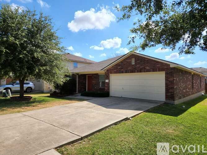 A house with a garage and a driveway in front of it.