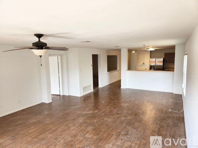 A room with wooden floors and a ceiling fan.