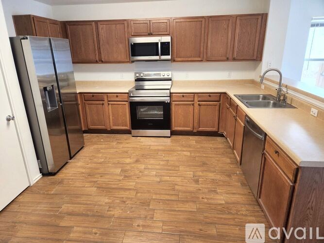 A kitchen with wooden cabinets and a refrigerator.