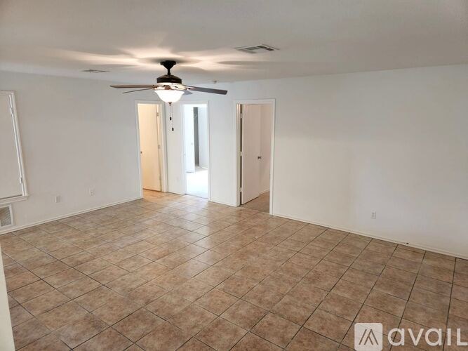 A room with a ceiling fan and tile flooring.