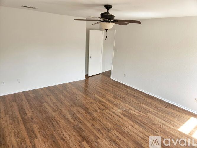 A room with wooden flooring and a ceiling fan.