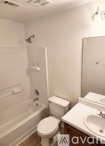 A white toilet sits next to a white sink in a small bathroom.