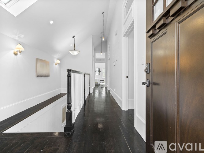 A long hallway with a skylight and a wooden floor.