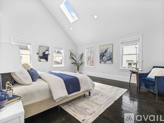 A bedroom with a bed, a chair, and pictures on the wall.