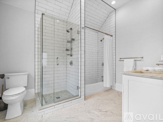 A white bathroom with a walk-in shower and a toilet.